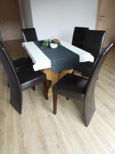 un tavolo con quattro sedie, un tavolo nero e una sedia a sdraio di Appartement Haus Petra a Leogang