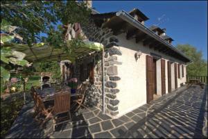 a house with a patio with a bird on the roof at Chambres d'Hôtes Le Moulin du Pont in Saint-Bonnet-de-Salers