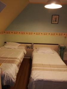 BrixにあるHôtel l'Edenのベッド2台が隣同士に設置された部屋です。