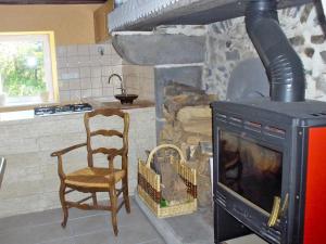 cocina con chimenea, silla y fogones en Holiday Home O'Petit Bonheur by Interhome, en Langlerial
