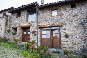 ブラガンサにあるCasa do Pomarの木の扉と石の小道がある石造りの家