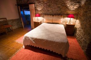 una camera da letto con un letto e due lampade sui tavoli di Casa do Pomar a Bragança Altre 17 foto