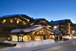 a ski lodge in the snow at night at Guarda Golf Hotel & Residences in Crans-Montana