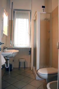 La salle de bains est pourvue de toilettes, d'un lavabo et d'une douche. dans l'établissement Hotel Engadina, à Côme