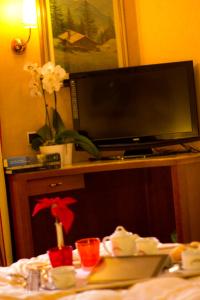 TV in cima a un tavolo in camera di Hotel Norden Palace ad Aosta