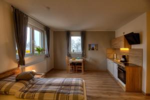 a bedroom with a bed and a kitchen with a table at Pader-Motel in Paderborn