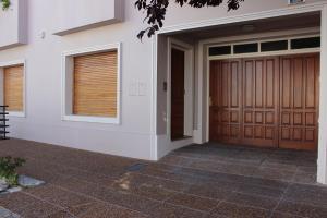 una casa con dos puertas de madera en el garaje en Casa Aurora en Olavarría