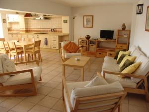 a living room with tables and chairs and a kitchen at Casa Duende del Tajo in Ronda