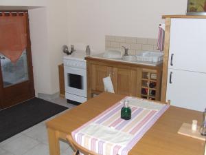 eine Küche mit einem Tisch und einer Flasche darauf in der Unterkunft Chez Helen in Marsac