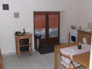 eine Küche mit einem Tisch und eine Tür mit einem Fenster in der Unterkunft Chez Helen in Marsac + 9 Fotos