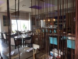 un restaurante con mesas, sillas y una pared de cristal en CONDO NORDELTA - Apart Departamento - COMPLEJO WYNDHAM - BAHIA GRANDE en Tigre