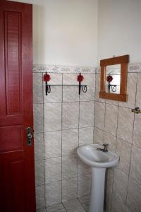 een badkamer met een witte wastafel en een spiegel bij Pousada do Getulio in Tiradentes