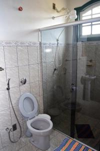 um banheiro com vaso sanitário e box de vidro em Pousada do Getulio em Tiradentes mais 33 fotografias