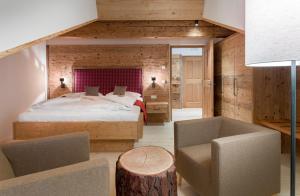 a bedroom with a bed and a table and a chair at Bruggerhof Prags in Braies