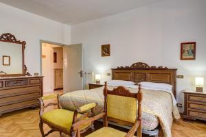1 dormitorio con 1 cama grande y 2 sillas en B&B Il Pozzo, en Sinalunga