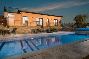 a house with a swimming pool in front of a house at Villa Guiné in Arco da Calheta