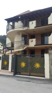 um edifício com um portão com dois sinais de sol sobre ele em Residence Mirage Milazzo em Milazzo