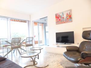 a living room with chairs and a flat screen tv at LE JAD, ROQUEBRUNE in Roquebrune-Cap-Martin