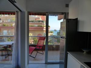 a kitchen with a sliding glass door to a balcony at LE JAD, ROQUEBRUNE in Roquebrune-Cap-Martin