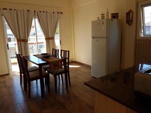 a kitchen with a table and a white refrigerator at LVN Apart in San Clemente del Tuyú