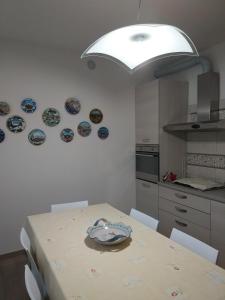 a kitchen with a table and plates on the wall at Marinella Guest House in Cornale