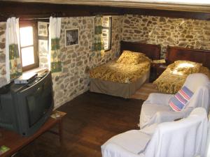 a living room with two beds and a tv at Auberge de Forgès in Forgès