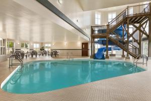 a swimming pool in a building with a slide at Days Inn by Wyndham Steinbach in Steinbach