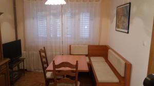 a small dining room with a table and a television at Family Apartments Marita in Makarska
