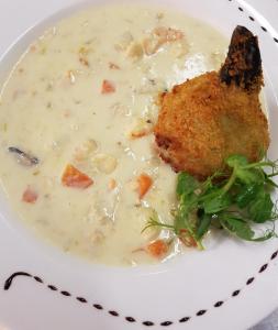 a plate of soup with a piece of chicken in it at Caisleain Oir Hotel in Annagry