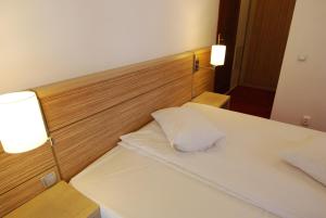a bedroom with two beds and two lights on the wall at Vila Amira Predeal in Predeal