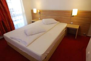 a large white bed in a room with a red carpet at Vila Amira Predeal in Predeal