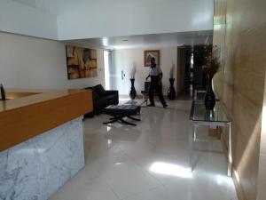 a man walking through a lobby of a building at Jardim Armação Salvador in Salvador