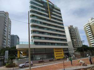 un edificio alto con un coche aparcado delante de él en Jardim Armação Salvador, en Salvador