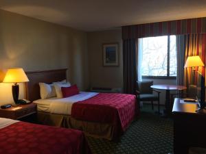 A bed or beds in a room at Mystic River Hotel & Suites