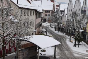 a snow covered street in a city with buildings at Outlet Fewo Metzingen in Metzingen