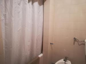 La salle de bains est pourvue d'un rideau de douche et de toilettes. dans l'établissement Albufeira INN - Casa da Luz - Bellavista T0, à Albufeira
