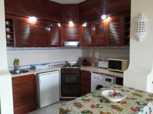 una pequeña cocina con armarios de madera y una mesa. en Albufeira INN - Casa da Luz - Bellavista T0 en Albufeira
