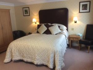 a bedroom with a large bed with a white comforter at The Golden Lion Hotel in Northallerton