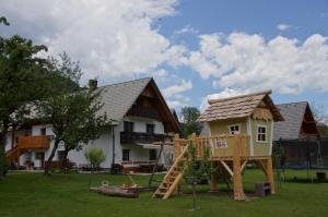 a playground in front of a house with a play structure at Apartments Markež in Bohinj