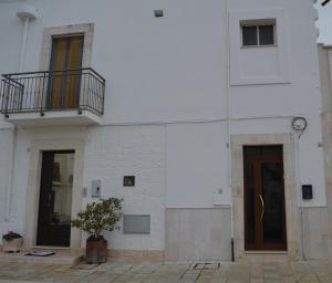 ein weißes Gebäude mit einer Tür und einem Balkon in der Unterkunft Casa Vacanze La Foggia in Alberobello