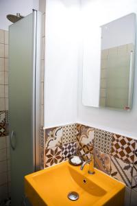uma casa de banho com um lavatório amarelo e um espelho. em Luky 12 em Brasov