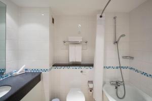 uma casa de banho com um WC, um lavatório e um chuveiro em Holiday Inn London Bloomsbury, an IHG Hotel em Londres