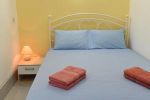 a bedroom with a white bed with two towels on it at Cosy Studio in Marsalforn