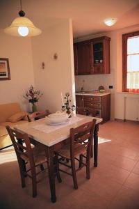 
a kitchen with a table, chairs and a refrigerator at Residence Podere Olmo in Sovicille
