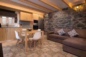 a kitchen and living room with a table and a couch at Casa do Leme in Arco da Calheta