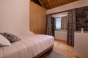 アルコ・ダ・カリェタにあるCasa do Lemeのベッドルーム(大型ベッド1台、窓付)