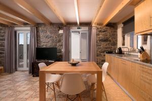 una cucina e una sala da pranzo con tavolo e sedie in legno di Casa do Leme ad Arco da Calheta