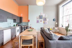 a kitchen and living room with a couch and a table at ALTIDO Modern flat in the city center in Edinburgh