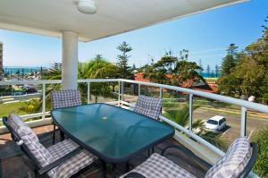 a balcony with a glass table and chairs at Mainsail 10 17 Owen Street in Port Macquarie