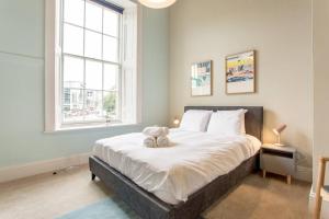 a bedroom with a bed with a teddy bear on it at ALTIDO Modern flat in the city center in Edinburgh